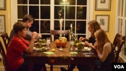 Jane Rassmussen's family sits down to a dinner inspired by her recent cooking lessons. (VOA/S. Koster)