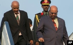 Sudan President Omar al-Bashir, right, arrives in Kigali, Rwanda, July 16, 2016, to attend an African Union summit. He defied an international warrant of arrest after public assurances from Rwandan leaders that he would not be arrested.