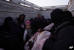 A baby is among men, women and children on a truck after being evacuated out of the last territory held by Islamic State militants, outside Baghuz, Syria, March 4, 2019.