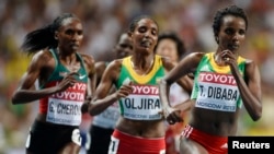 L'éthiopienne Tirunesh Dibaba (à droite) court devant l'Éthiopienne Belaynesh Oljira au 10,000 mètres dames à Moscou, le 11 août 2013. 