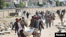 Relatives carry bodies of the victims of air strikes on a detention center to be buried at a cemetery in Saada, Yemen January 25, 2022.