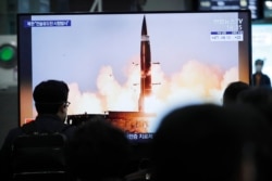 People watch a TV showing an image of North Korea's new guided missile during a news program at the Suseo Railway Station in Seoul, South Korea, Friday. March 26, 2021.