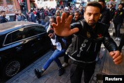 A police officer gestures towards camera as they detain a demonstrator during a protest to defy a ban and march on Taksim Square to celebrate May Day in Istanbul, Turkey May 1, 2023. (REUTERS/Kemal Aslan)