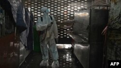 ក្រុមការងារម្នាក់ដែលស្ថិតក្នុងសម្លៀកបំពាក់ការពារមេរោគ កំពុងបាញ់ថ្នាំសម្លាប់មេរោគនៅក្នុងផ្សារអូរឬស្សីដែលបានបិទ បន្ទាប់ពីមានករណីឆ្លងជំងឺកូវីដ១៩ ក្នុងចំណោមអាជីវករ នៅរាជធានីភ្នំពេញ ថ្ងៃទី ៤ ខែមេសា ឆ្នាំ ២០២១។