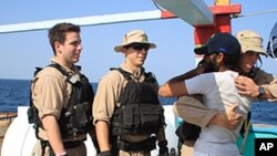 U.S. Navy sailors assigned to the guided-missile destroyer USS Kidd greet a crew member of the Iranian fishing vessel, the Al Molai Friday, Jan. 6, 2012 in the Arabian Sea. The fishermen were rescued by a U.S. Navy destroyer Thursday, more than 40 days a