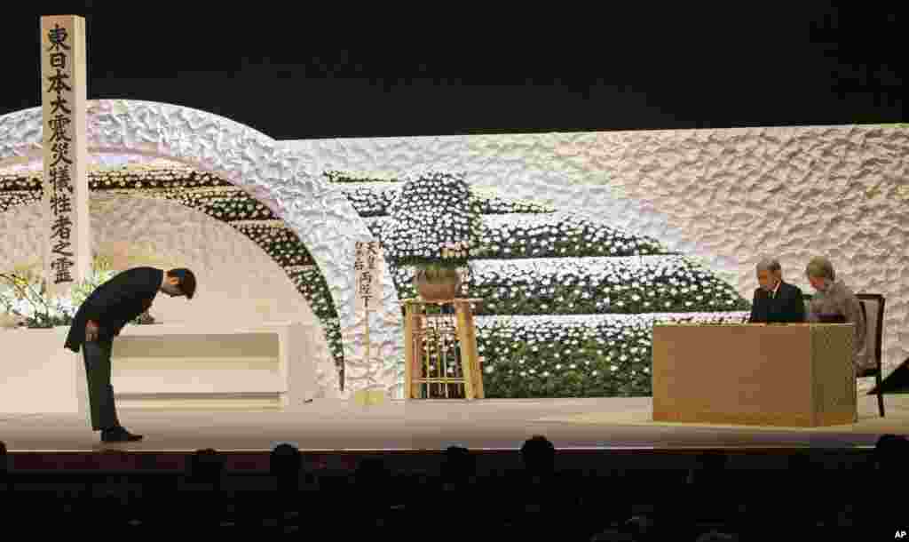 Japanese Prime Minister Shinzo Abe bows to Emperor Akihito and Empress Michiko during the national memorial service for the victims of the March 11, 2011, earthquake and tsunami in Tokyo, March 11, 2013.