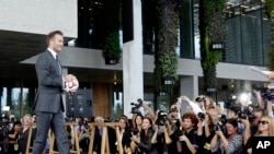 Mantan bintang sepakbola Inggris David Beckham memegang bola di konferensi pers ketika ia mengumumkan akan membeli tim ekspansi Major League Soccer, Miami, 5 Februari 2014.