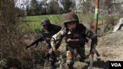 Tentara India mengambil posisi saat mengepung rumah militan di luar kota Srinagar, Kamis pagi 21 Oktober 2010.