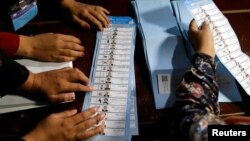 Para petugas KPU Afghanistan mulai menghitung surat suara hasil pilpres hari Sabtu 28/9. 