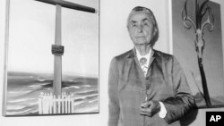 FILE - Georgia O'Keeffe stands next to her oil paintings during a press review of 121 paintings, watercolors, and drawings on exhibit at the Whitney Museum of American Art in New York, Oct. 8, 1970. 