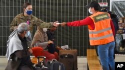 FILE - Afghan refugees are seated as they are being processed inside Hangar 5 at Ramstein Air Base in Germany, Sept. 8, 2021.