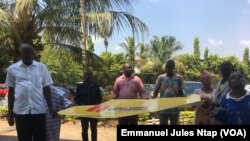 Quelques défenseurs de l’environnement déroulent un message contre la criminalisation de leur activisme à Yaoundé, le 9 décembre 2019. (VOA/Emmanuel Jules Ntap)