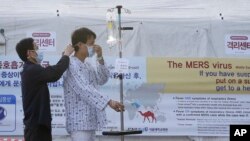 A patient dons a mask to protect against MERS, Middle East Respiratory Syndrome, at Seoul National University Hospital in South Korea, June 1, 2015. 