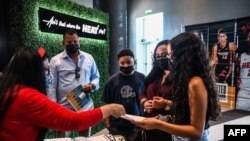 Lorena Torres (2R) mother of 15-year-old Valentina Jimenez (R) is being assisted by the staff of Miami Heat during a COVID-19 vaccination event hosted by Miami Heat at FTX Arena in Miami, on Aug. 5, 2021. 