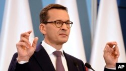 Polish Prime Minister Mateusz Morawiecki presents the joint declaration of the prime ministers of Israel and Poland, in his chancellery in Warsaw, June 27, 2018. Poland’s President Andrzej Duda has signed into law amendments that abolish the threat of prison for anyone who blames Poland for Nazi Germany’s Holocaust crimes.