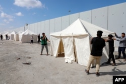 อาสาสมัครและเอ็นจีโอ ติดตั้งเต๊นท์ที่ด่านราฟาห์ ชายแดนอียิปต์-ฉนวนกาซ่า เพื่อเตรียมรับผู้อพยพที่อยู่อีกฝั่ง ภาพวันที่ 19 ตุลาคม 2023 (ที่มา: AFP)