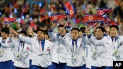 지난 4일 인천 아시안게임 폐막식에서 북한 선수단이 인공기를 흔들며 경기장으로 들어서고 있다.