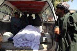 Afghan villagers sit in the back of a vehicle carrying dead bodies to a hospital following an airstrike in Helmand province, Sept. 23, 2019.