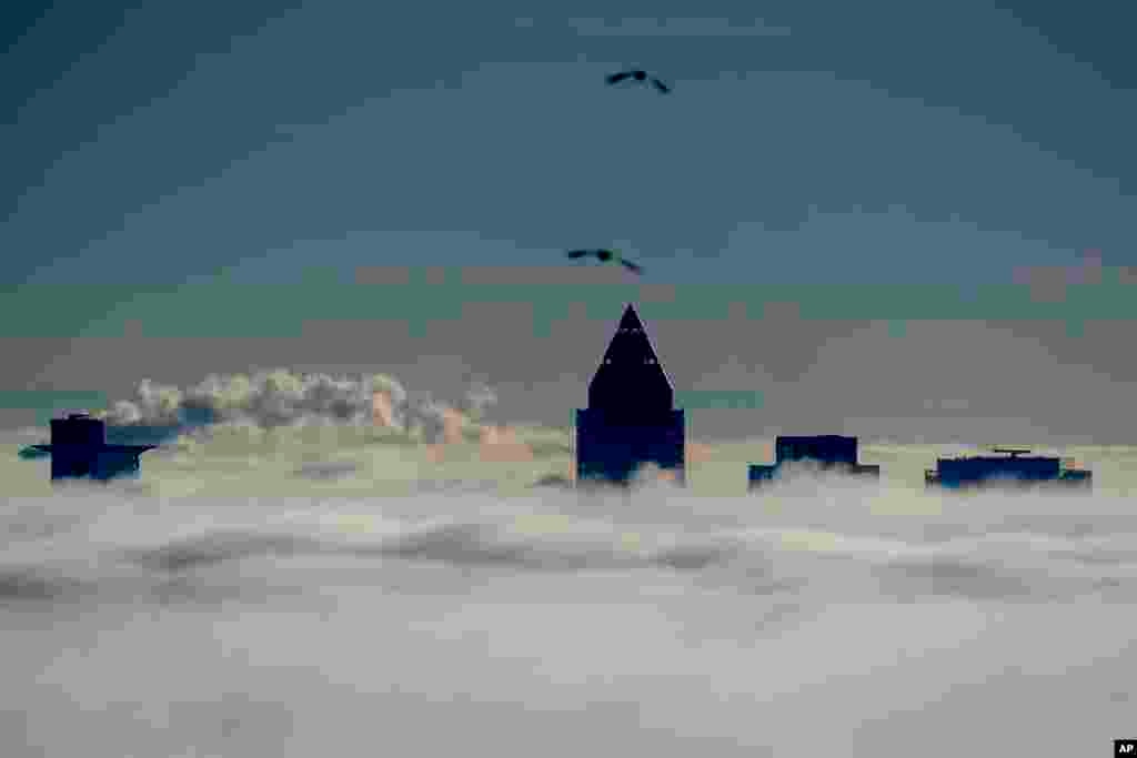 The buildings of the banking district come out of the thick fog over Frankfurt, Germany.