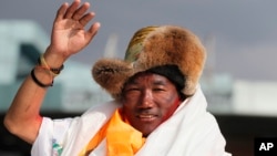 Nepalese veteran Sherpa guide, Kami Rita, 48, waves as he arrives in Kathmandu, Nepal, Sunday, May 20, 2018. (AP Photo/Niranjan Shrestha)