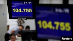 Employees of a foreign exchange trading company work under monitors displaying the Japanese yen's exchange rate against the U.S. dollar in Tokyo, Japan, June 16, 2016.
