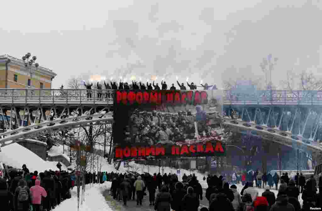 Activists burn flares during a protest against the extension of police authority and power, in central Kyiv, Ukraine.