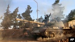 Un volontaire combattant avec les forces gouvernementales syriennes assis sur un char dans la province de Raqqa, Syrie, 17 février 2016. (Alexander Kots / Komsomolskaya Pravda via AP)