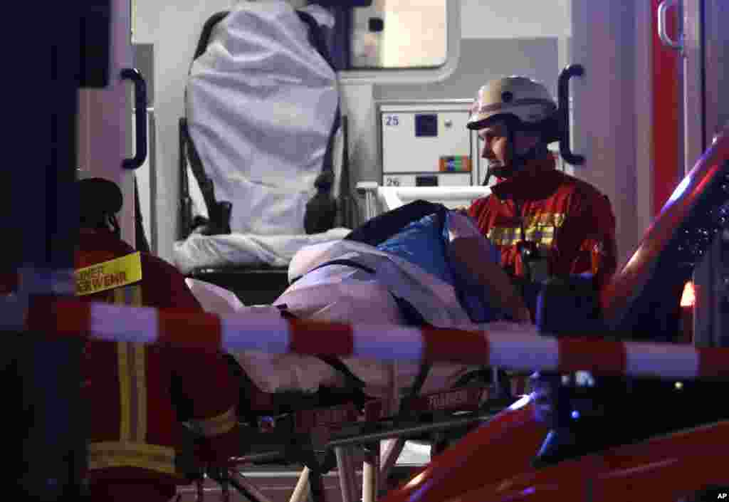 Firefighters load an injured person into an ambulance after a truck ran into a crowded Christmas market and killed several people in Berlin, Germany, Dec. 19, 2016.