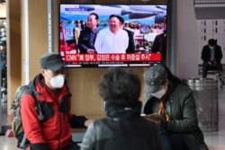 People watch a television news broadcast showing file footage of North Korean leader Kim Jong Un, at a railway station in Seoul on April 21, 2020.