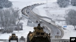 A convoy of Russian armored vehicles moves along a highway in Crimea, Jan. 18, 2022. Russia has concentrated an estimated 100,000 troops with tanks and other heavy weapons near Ukraine in what the West fears could be a prelude to an invasion.