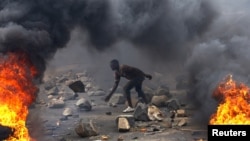 FILE - A protester sets up a barricade during a protest against Burundi President Pierre Nkurunziza and his bid for a third term in Bujumbura, Burundi, May 22, 2015. 