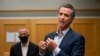 FILE - California Governor Gavin Newsom, right, speaks during a tour of a cooling center in Sacramento, California, Aug. 18, 2020. Newsom declared an emergency Tuesday over wildfires burning throughout the state.