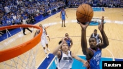 Serge Ibaka d’ Oklahoma City Thunder (9) amorce une attaque vers le panier face à Dirk Nowitzki de Dallas Mavericks (41) lors d’un match de la NBA à Dallas, Texas, 7 mai 2011.