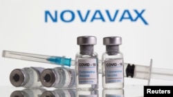Botol berlabel "Covid-19 Coronavirus Vaccine" dan sryinge terlihat di depan logo Novavax dalam ilustrasi ini, 9 Februari 2021. (Foto: REUTERS/Dado Ruvic)