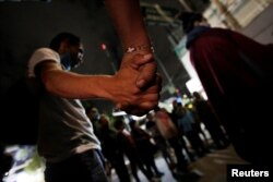 People join hands in prayer, at the site of a collapsed building, after an earthquake in Mexico City, Mexico Sept. 23, 2017.