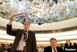 지난 2013년 12일 스위스 제네바에서 열린 유엔 인권이사회에서 미국의 로버트 킹 북한인권특사(오른쪽)가 발언하기 위해, 미국 대사관 관계자가 명패를 들고 있다.