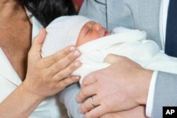 Britain's Prince Harry and Meghan, Duchess of Sussex, during a photocall with their newborn son, in St George's Hall at Windsor Castle, Windsor, south England, May 8, 2019.