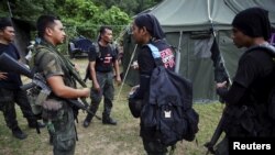 Members of special police force chat after returning to a police camp near Wang Kelian in northern Malaysia, close to the border with Thailand May 25, 2015. Malaysian authorities have found 139 graves, and signs of torture, in more than two dozen squalid