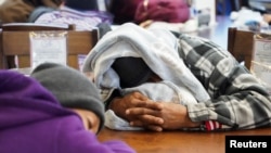 Orang-orang berlindung di toko Gallery Furniture yang diubah menjadi tempat menghangatkan diri setelah badai musim dingin menyebabkan listrik padam di Houston, Texas, Rabu, 17 Februari 2021.