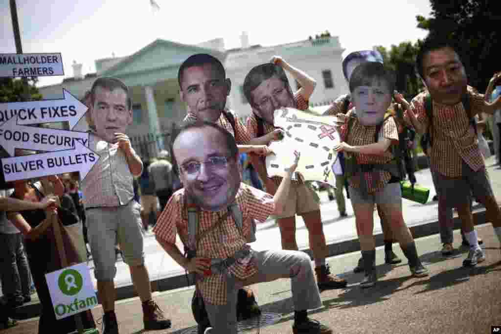 Oxfam activist wearing masks depicting G-8 world leaders participate in a demonstration outside the White House in Washington, May 17, 2012.