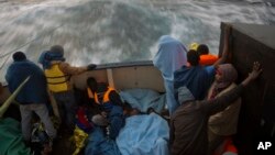 Para migran Afrika diselamatkan dari perahu karet beristirahat di kapal milik kelompok bantuan "Proactive Open Arms", di Lepas Pantai Libya (foto: dok). 