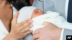 FILE - Britain's Prince Harry and Meghan, Duchess of Sussex, during a photocall with their newborn son, in St George's Hall at Windsor Castle, Windsor, south England, May 8, 2019.
