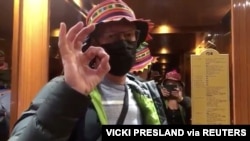 Diamond Princess cruise ship passenger Chris Peck, who shared a room with Vicki Presland (taking video) gestures in the elevator while disembarking the ship, after a quarantine for the coronavirus disease outbreak, in Yokohama, Japan Feb. 19, 2020.