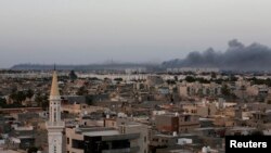 FILE - Plumes of black smoke are seen after war planes struck Misrata positions in Tripoli in an attack claimed by renegade general Khalifa Haftar, Aug. 23, 2014. 