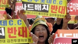 FILE - A resident in a rural South Korean town shouts slogans to protest a plan to deploy an advanced U.S. missile defense system called Terminal High-Altitude Area Defense, or THAAD, in their neighborhood, in Seoul, South Korea.