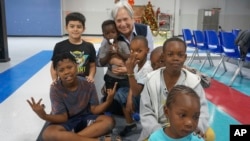 Sister Norma Pimentel, the director of Catholic Charities of the Rio Grande Valley, plays with migrant children on the floor of the Humanitarian Respite Center in McAllen, Texas, on Dec. 15, 2022.