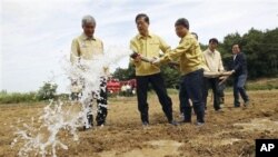 PM Korea Selatan Kim Hwang-sik (kedua dari kiri) menyiramkan air saat meninjau tanah pertanian di Hwaseong. Semenanjung Korea tengah dilanda kekeringan parah.