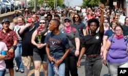 Demonstrators against racism march along city streets as they mark the anniversary of last year's Unite the Right rally in Charlottesville, Va., Sunday, Aug. 12, 2018.