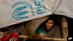 A Rohingya Muslim looks out of his make shift tent at Balukhali refugee camp 50 kilometres (32 miles) from Cox's Bazar, Bangladesh, Sunday, Jan. 14, 2018. In the Rakhine state of Myanmar, government troops have been accused of "ethnic cleansing" that has forced more than 655,000 Rohingya Muslims to flee into Bangladesh. (AP Photo/Manish Swarup)
