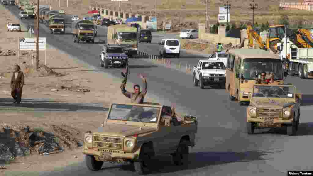 A convoy of Kurdish peshmerga fighters drives through Irbil after leaving a base in northern Iraq, on their way to Kobani, Syria, Oct. 28, 2014. 